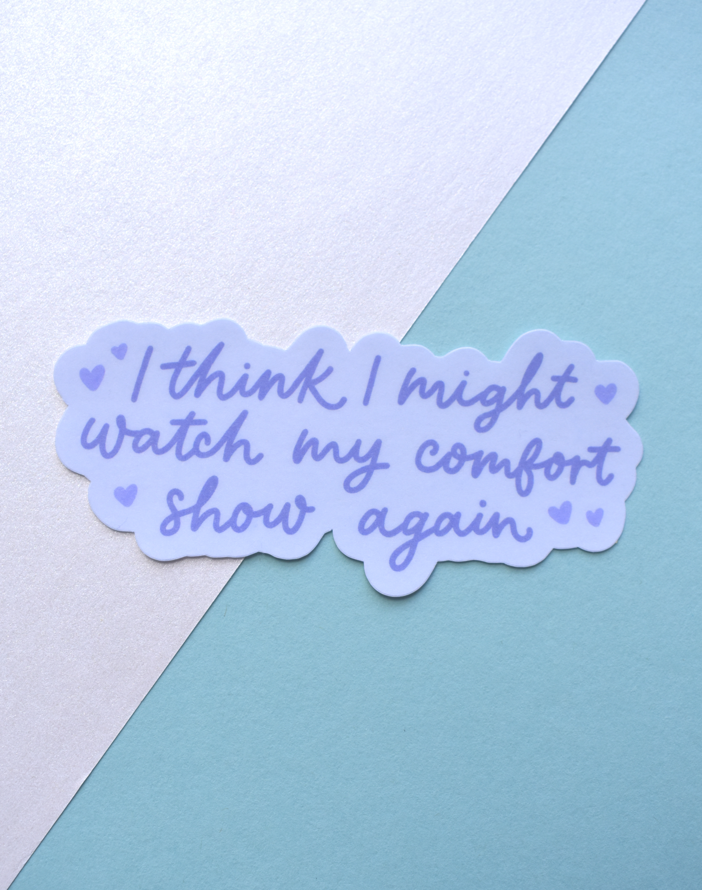 Sticker with text 'I think I might watch my comfort show again' on a pastel background