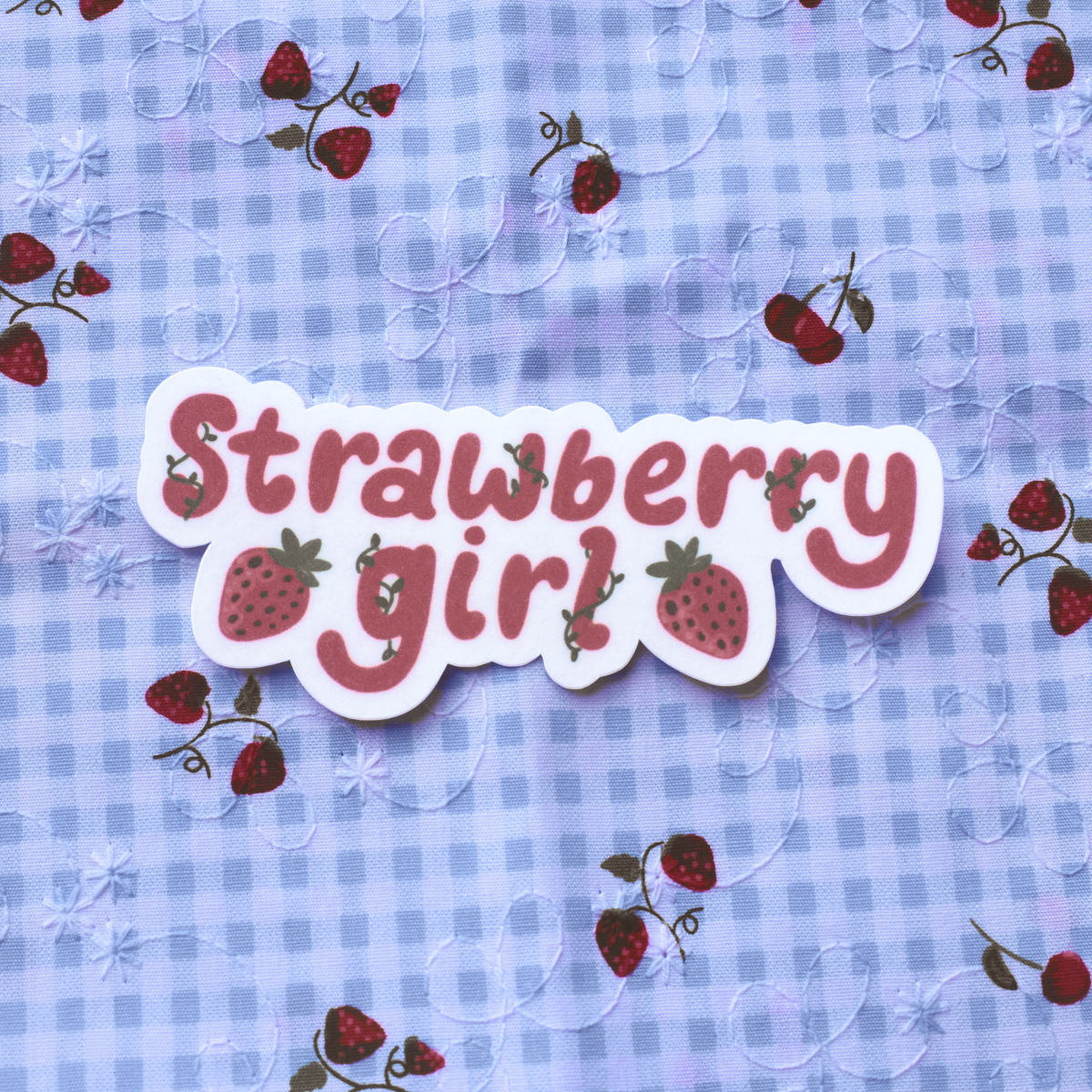 Text 'Strawberry girl' on a blue checkered background with strawberry illustrations