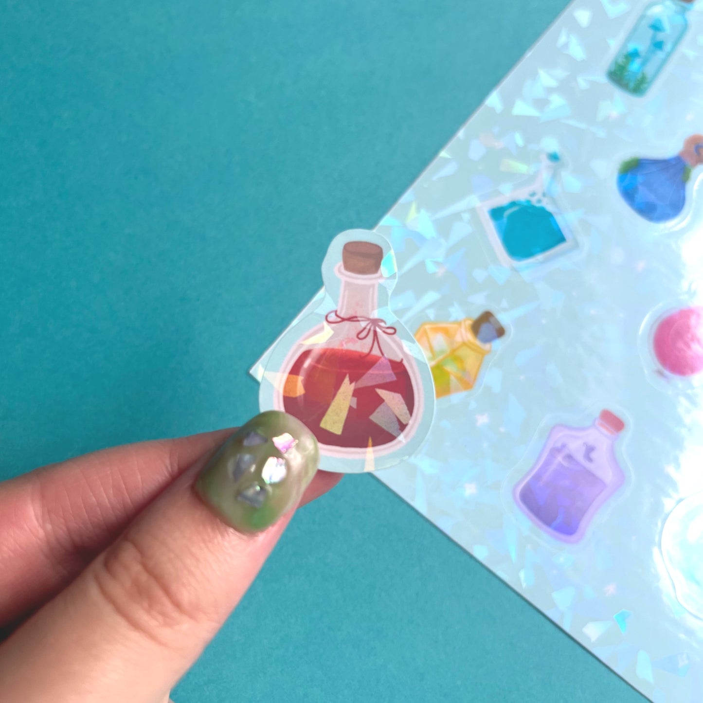 Close-up of holographic potion bottle vinyl stickers showing colourful magical bottle details