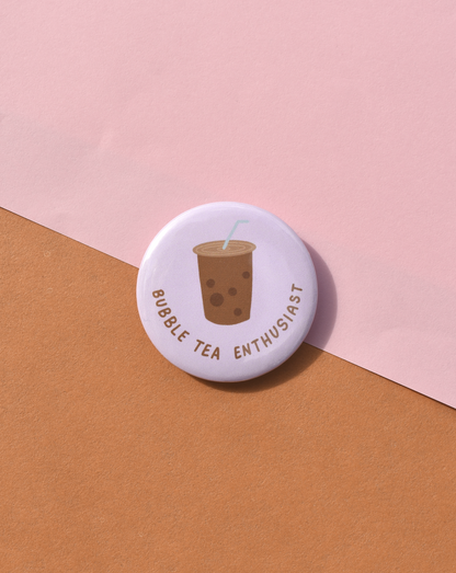 Button badge with bubble tea illustration and text on a pink and orange background