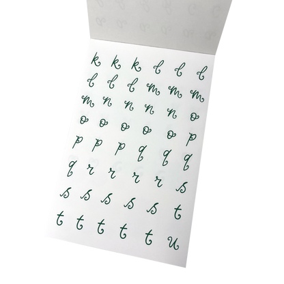 A sheet of green alphabet stickers showing lowercase cursive letters from k through to u. 