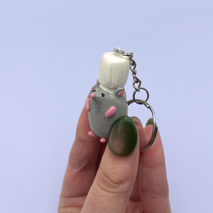Cute rat fimo keychain with a hand holding it