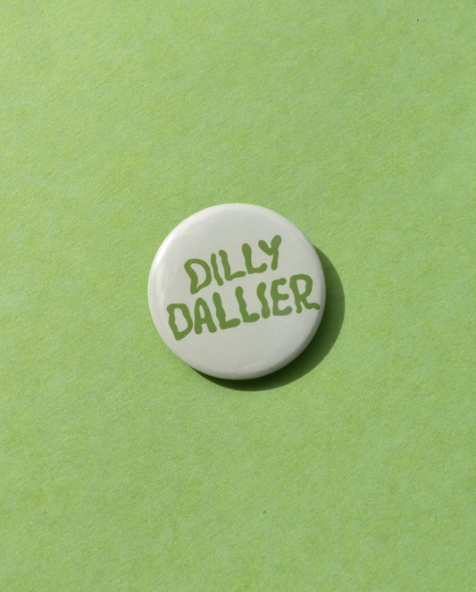 Round white button with 'Dilly Dallier' text on a green background