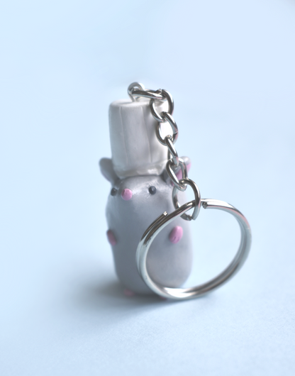 Keychain with a small rat with a chef hat figure on a light blue background