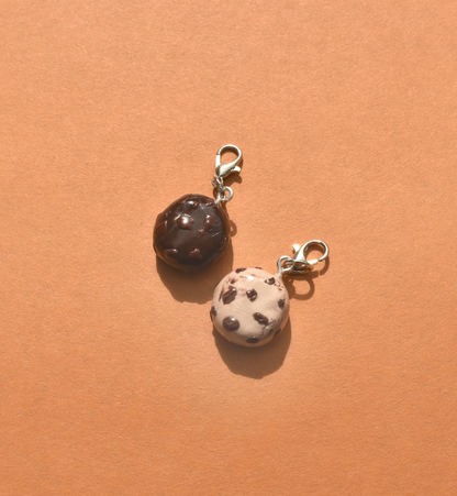 Two cookie-shaped charms on a peach-colored background