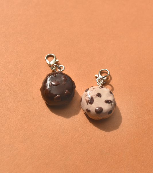 Two cookie charm pendants on a brown background