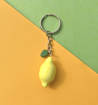 Lemon-shaped keychain on a yellow and green background