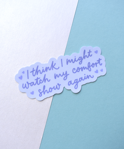 Sticker with text 'I think I might watch my comfort show again' on a light blue and white background