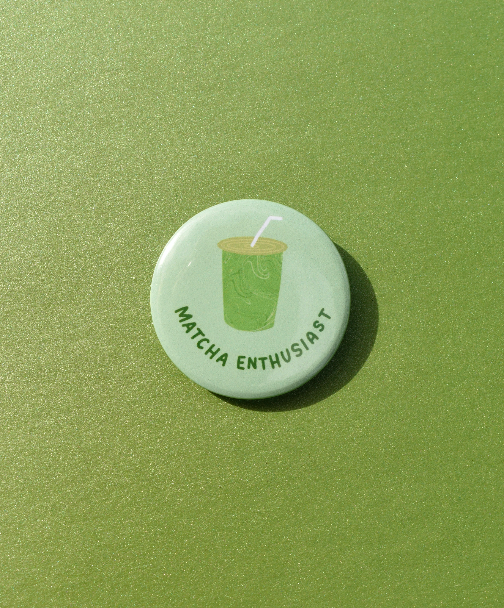 Button badge with 'Matcha Enthusiast' text and matcha green tea cup icon on a green background