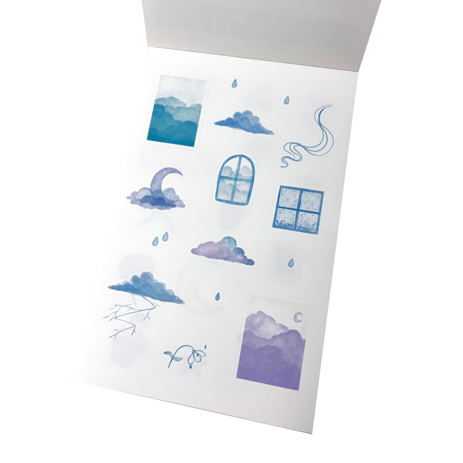 A matte white vinyl sticker sheet of watercolour-style cloud and sky illustrations in blue and purple tones.