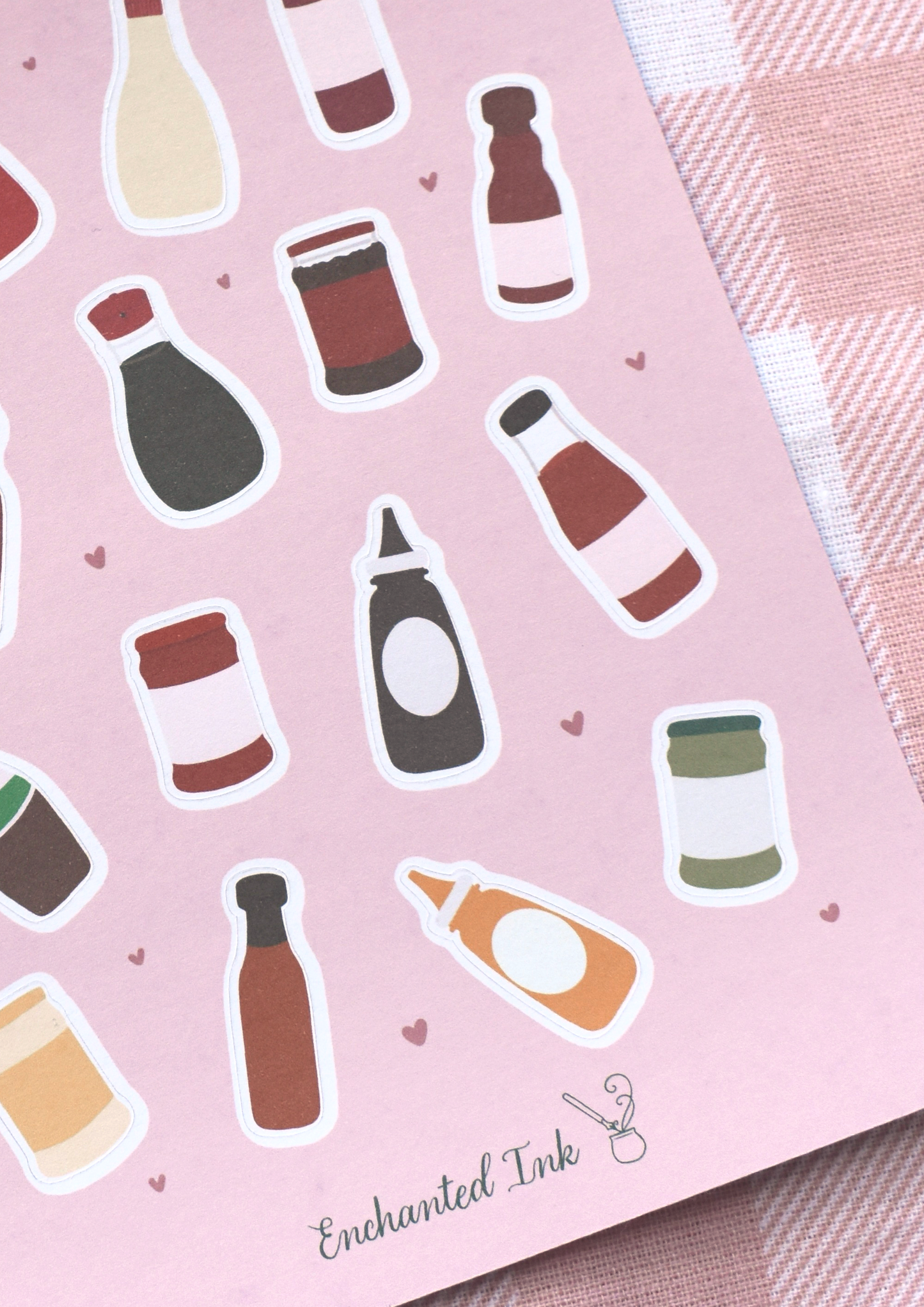 Sticker sheet with bottle illustrations on a pink background, featuring the brand 'Enchanted Ink'.