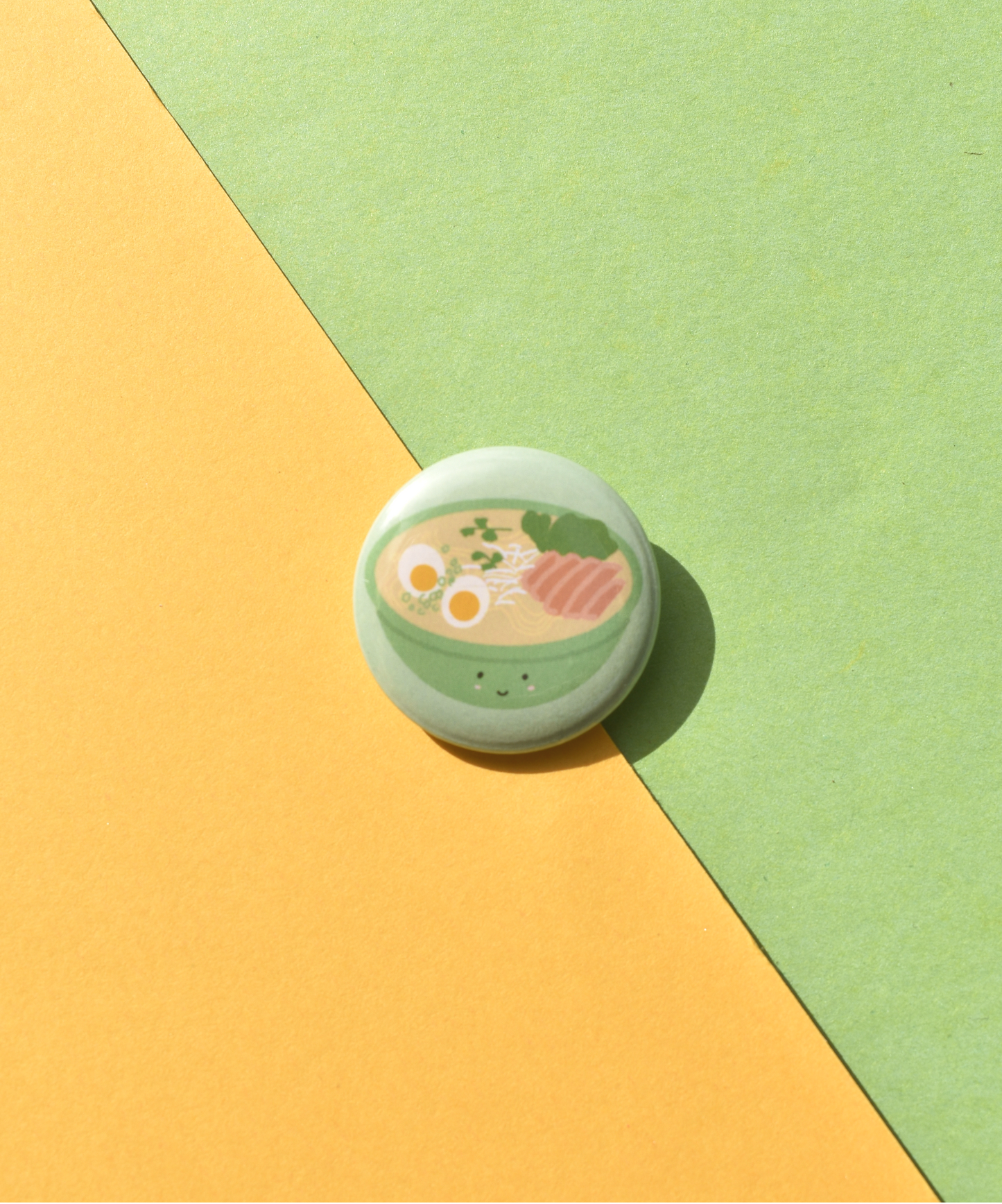 Round green button badge with a ramen design on a yellow and green background