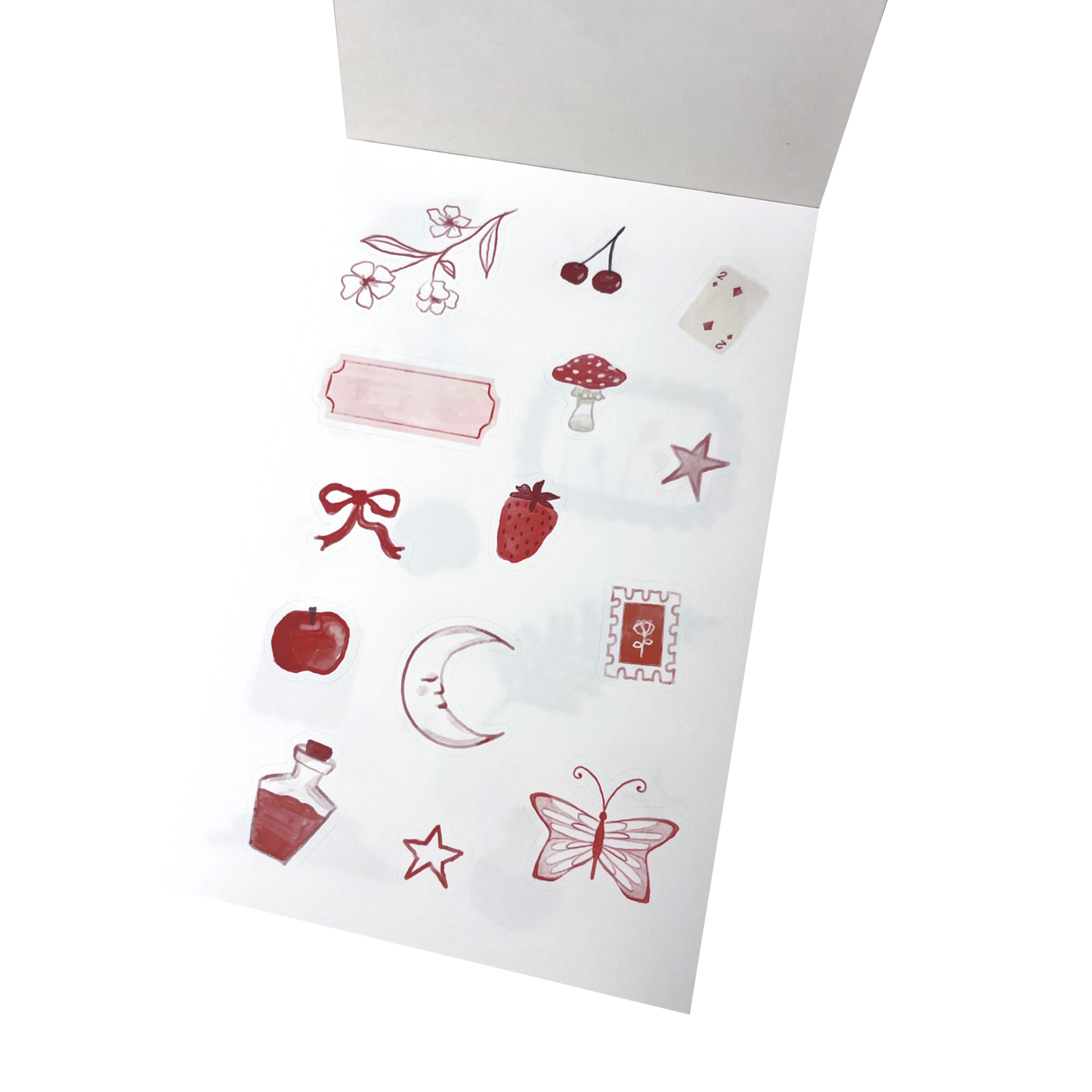 A sheet of decorative stickers with red and pink illustrations, including cherries, a strawberry, a mushroom, a bow, a crescent moon, stars, a butterfly, and a small bottle.