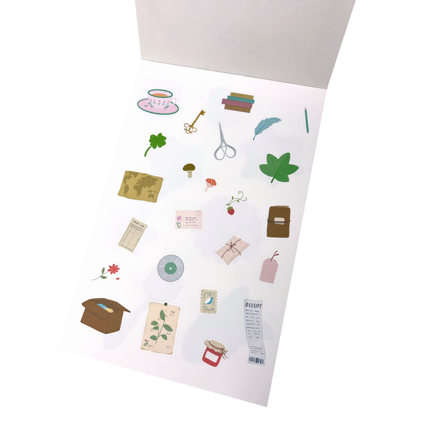 A sheet of illustrated stationery stickers. The stickers include small drawings such as a teacup, books, a key, scissors, a mushroom, a world map, envelopes, a box, a ticket, and small decorative motifs in muted pastel and earthy tones.