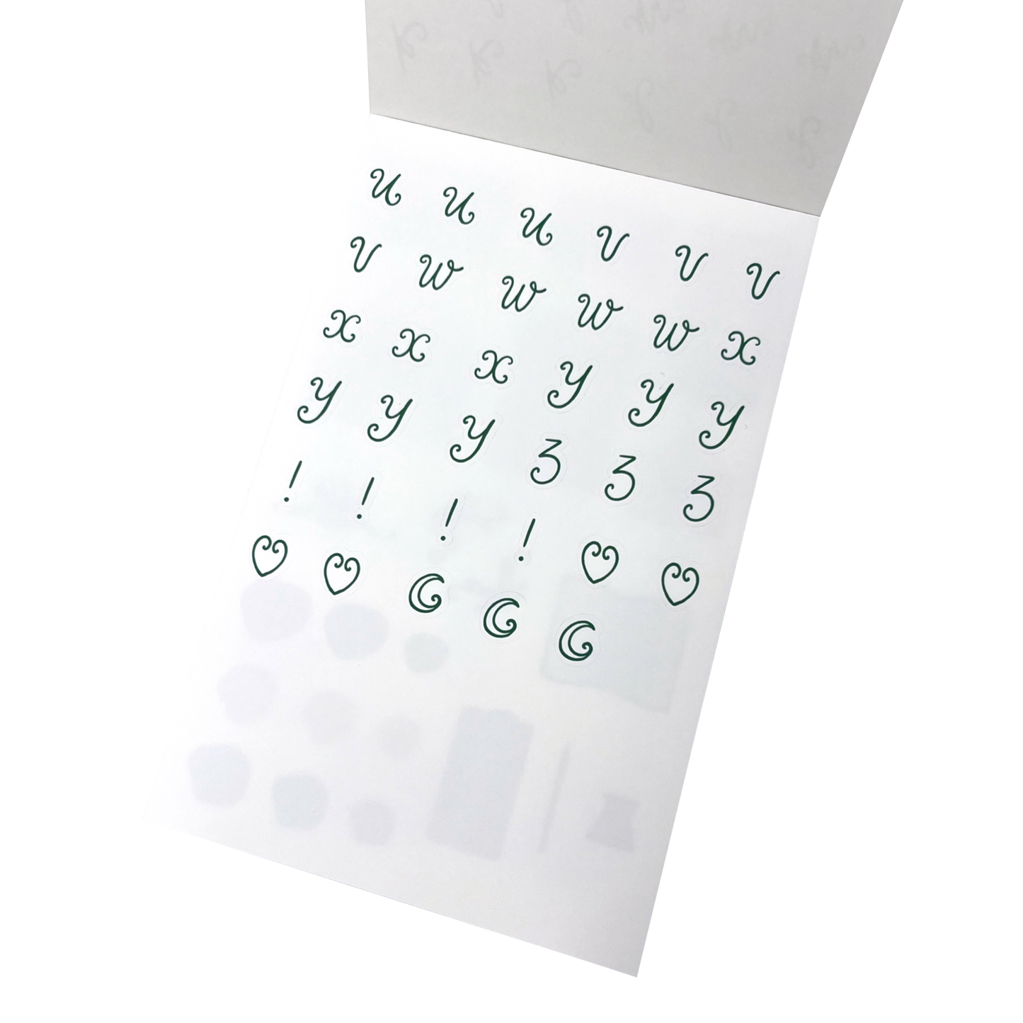 A sheet of green lettering stickers with letters u through to z, and exclamation marks, heart shapes and moons.