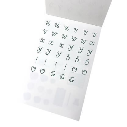 A sheet of green lettering stickers with letters u through to z, and exclamation marks, heart shapes and moons.