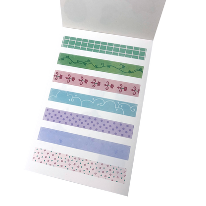 A sticker sheet of decorative washi tape strips featuring various patterns including green grid, green vine, pink floral, light blue scalloped, purple polka dots, lavender stripes, and a pink floral print.