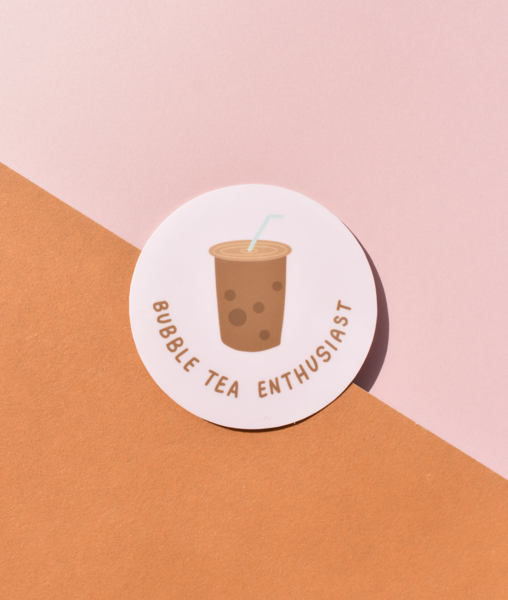 Round sticker with bubble tea illustration and text on a pink and orange background