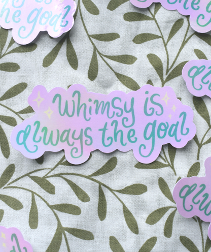 Sticker with 'Whimsy is always the goal' text on a leaf-patterned background