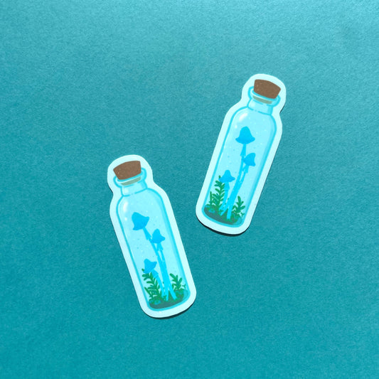 Blue mushroom potion vinyl sticker with tall mushrooms in clear jar, cork stopper and blue background