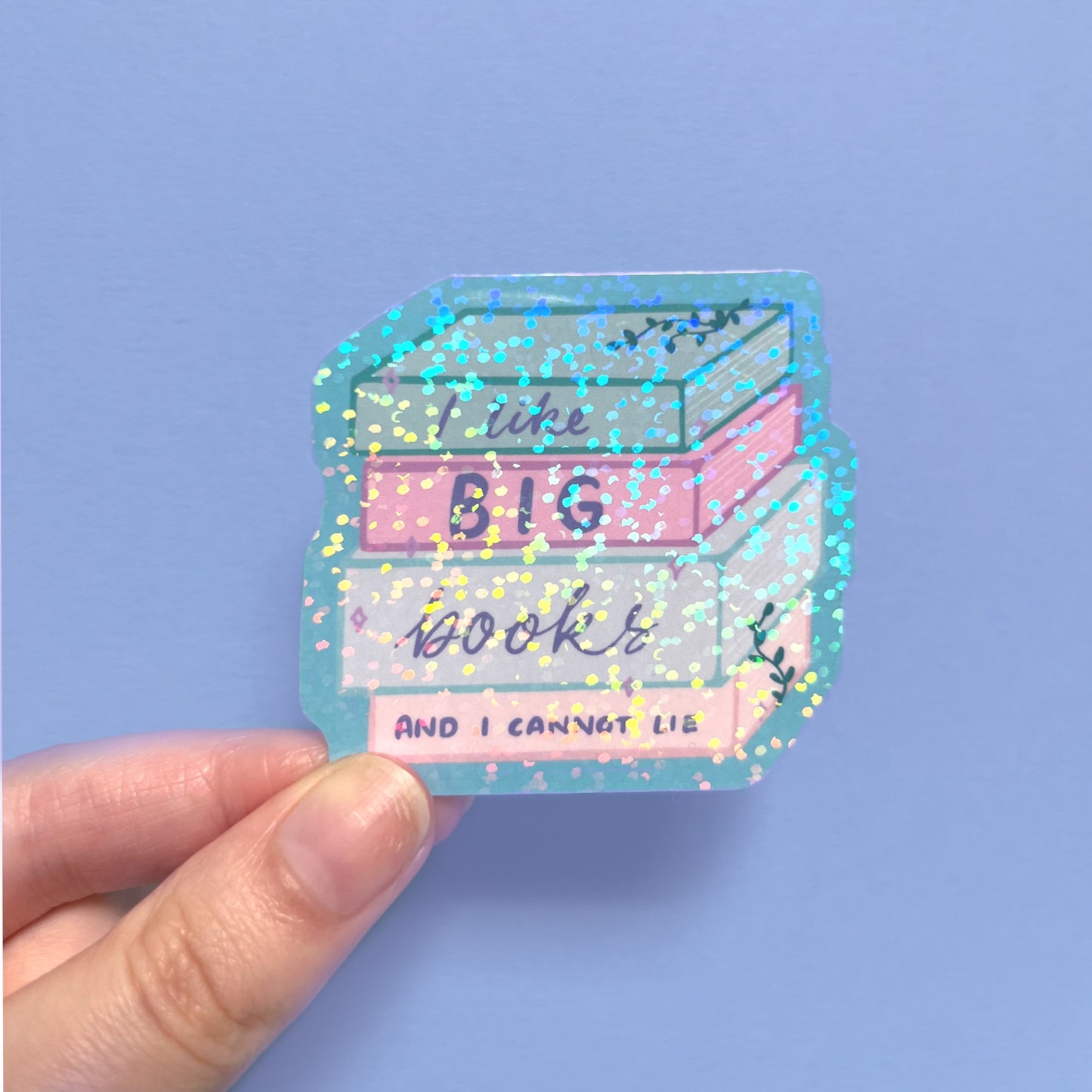 Holographic book lover sticker shown in hand for size reference