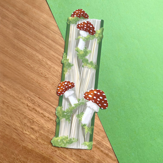 Glossy fantasy bookmark featuring a closed book with mushrooms and moss growing from the pages