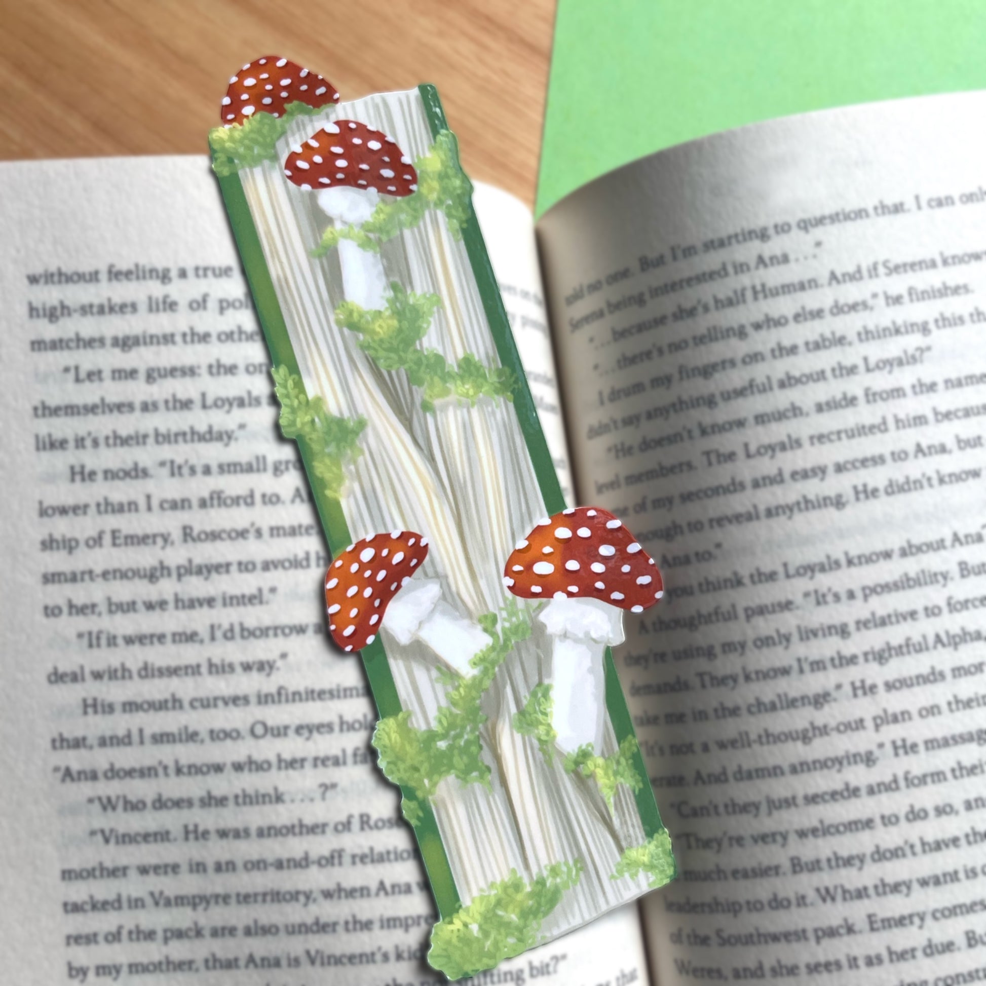 Close-up of glossy enchanted book bookmark showing mushroom and moss details