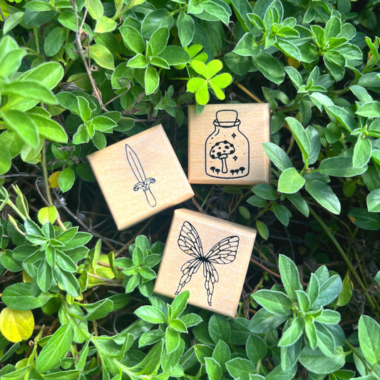 Fantasy rubber stamp trio featuring fairy wings sword and mushroom in a jar designs
