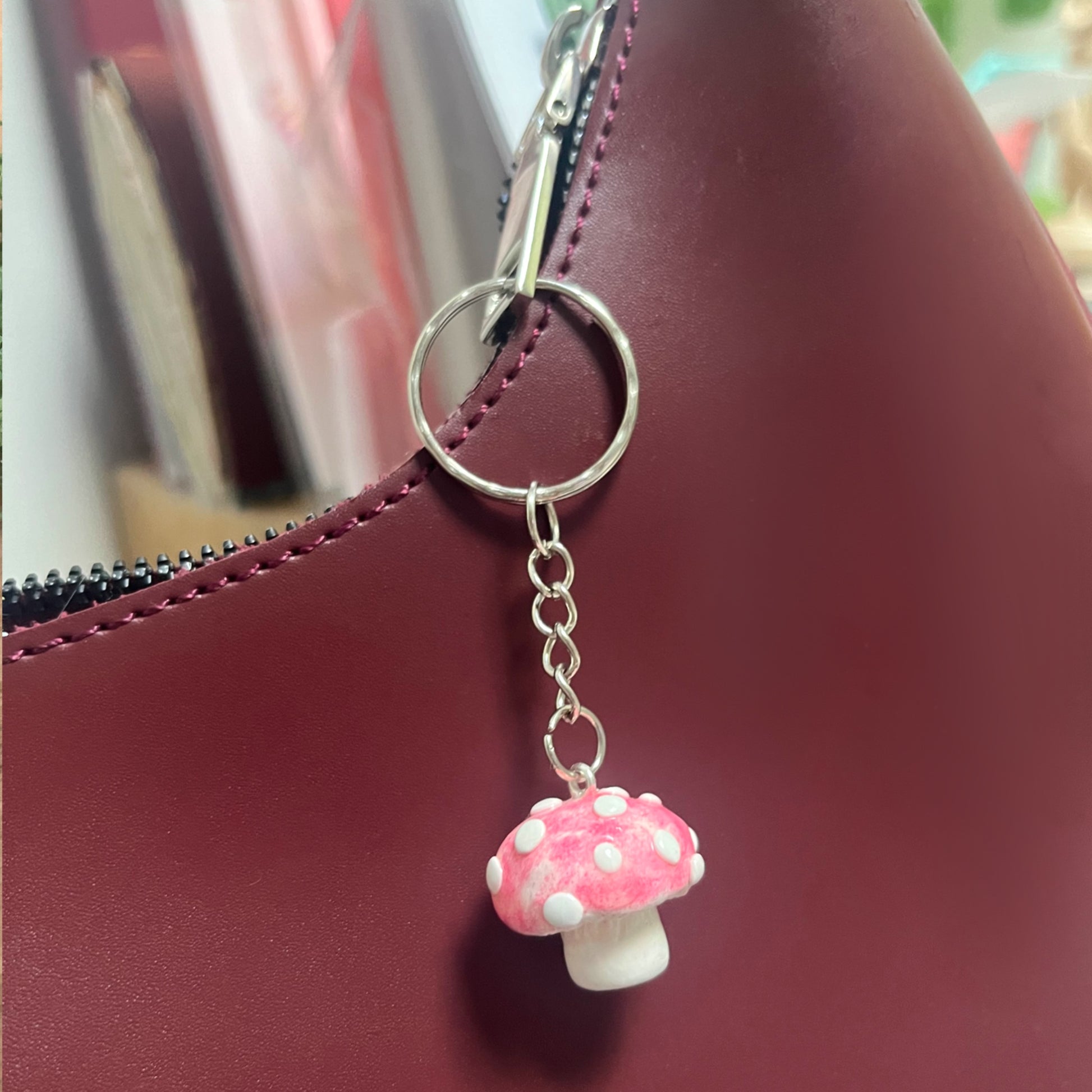 Handmade polymer clay mushroom keychain decorating a bag – whimsical cottagecore charm