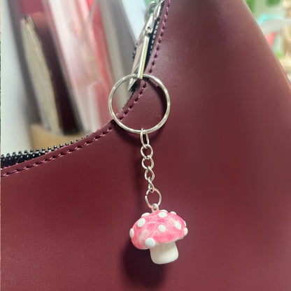 Handmade polymer clay mushroom keychain decorating a bag – whimsical cottagecore charm