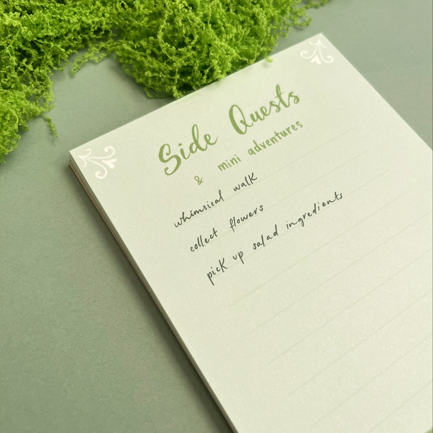 Close-up of Side Quests & Mini Adventures fantasy notepad showing whimsical artwork and writing space