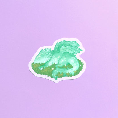 Sleeping baby dragon vinyl sticker with light green dragon resting on leaves
